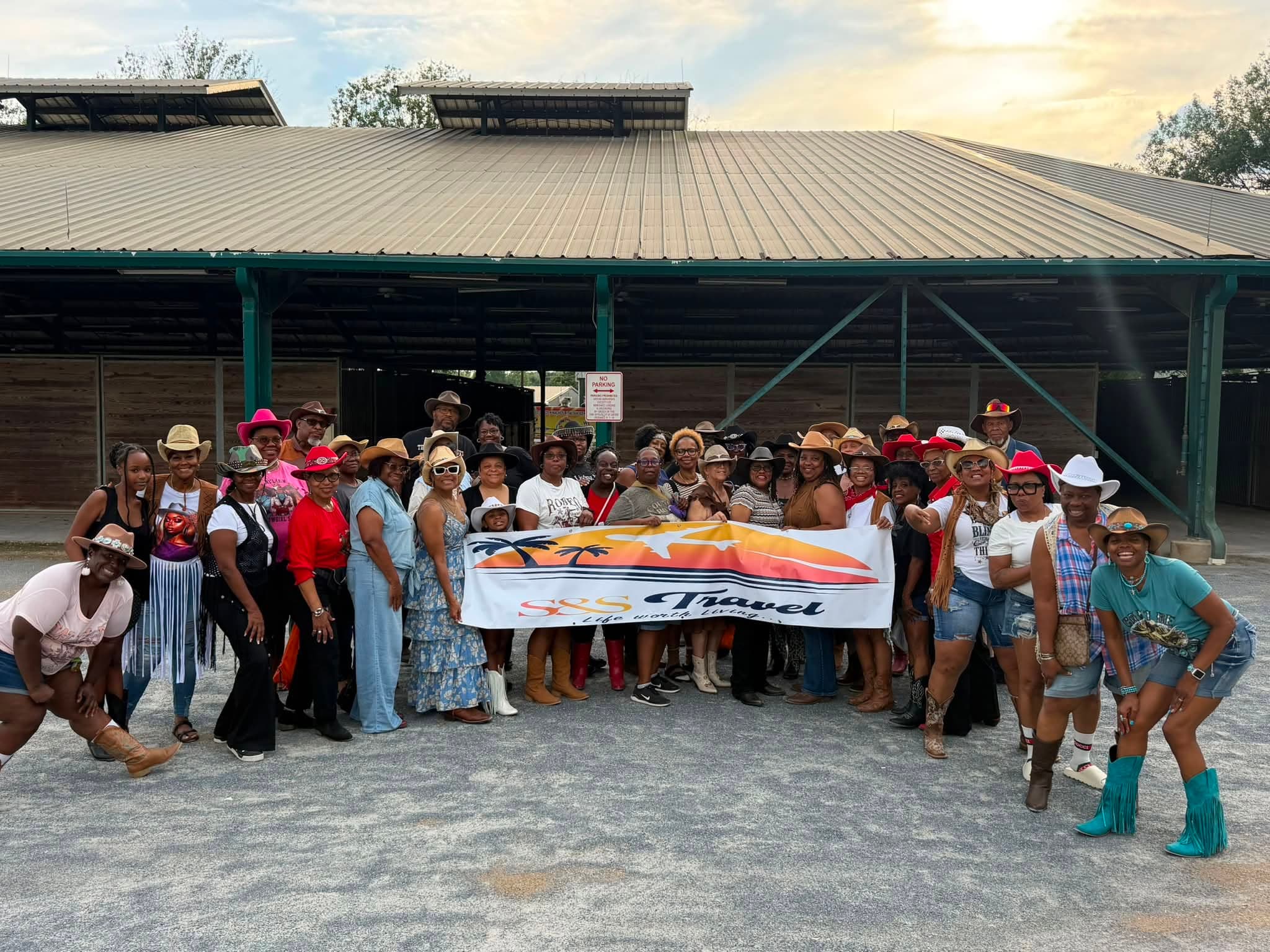 S&S Travel clients together on a group getaway, holding the S&S Travel banner